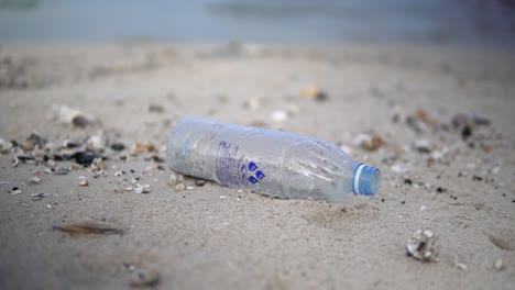 empty plastic bottle littered on the beach sand