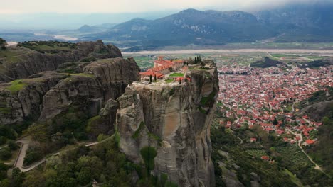 High drone orbit of Great Meteoron Monastery perched on Meteora cliff under sunny skies
