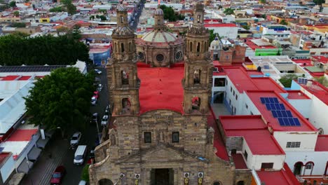 slow motion aerial overlooking dulce nombre de jesús church facade, bell towers and red roof in guadalajara, jalisco, mexico