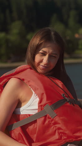 una mujer y una niña exploran el entorno natural desde un catamarán. una madre y una estudiante y su hija se estrellan por el sol brillante moviéndose en el lago azul en cámara lenta. vacaciones familiares en un complejo turístico