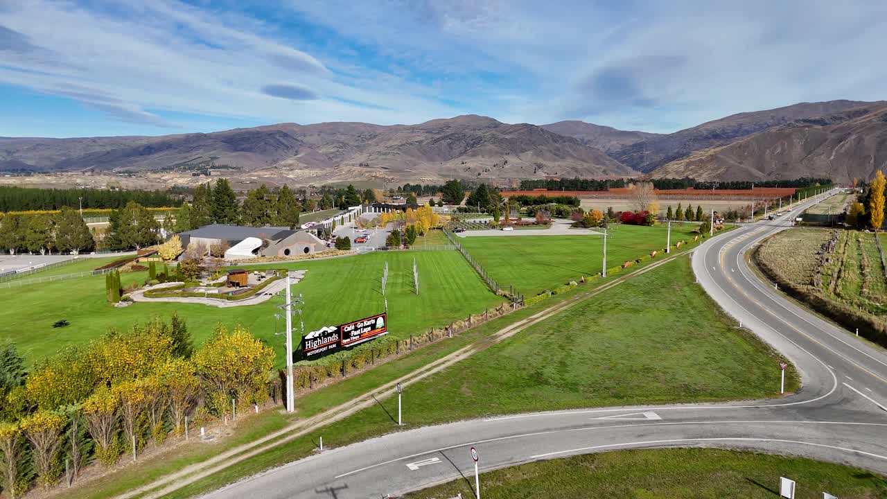 Aerial footage captures Cromwell's Highlands Motorsport Park with vibrant autumn colors and scenic mountain backdrop under clear skies