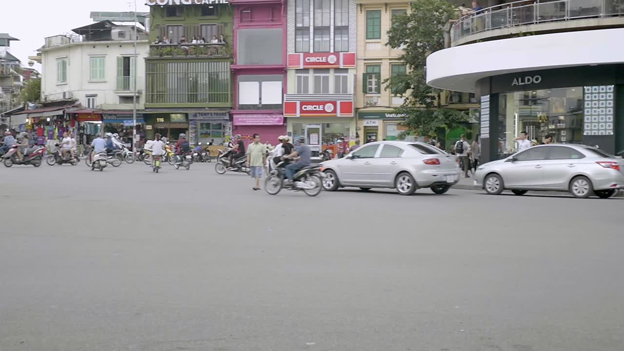 Hanoi, Vietnam -  Vietnamese ride their motorcycle in one of the roundabouts in the city-wide shot