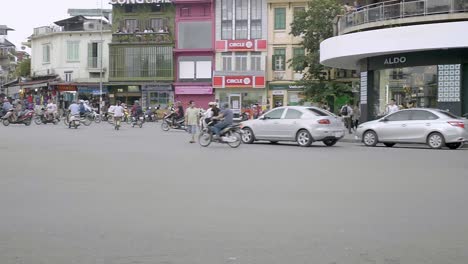 hanoi, vietnam -  vietnamese ride their motorcycle in one of the roundabouts in the city-wide shot