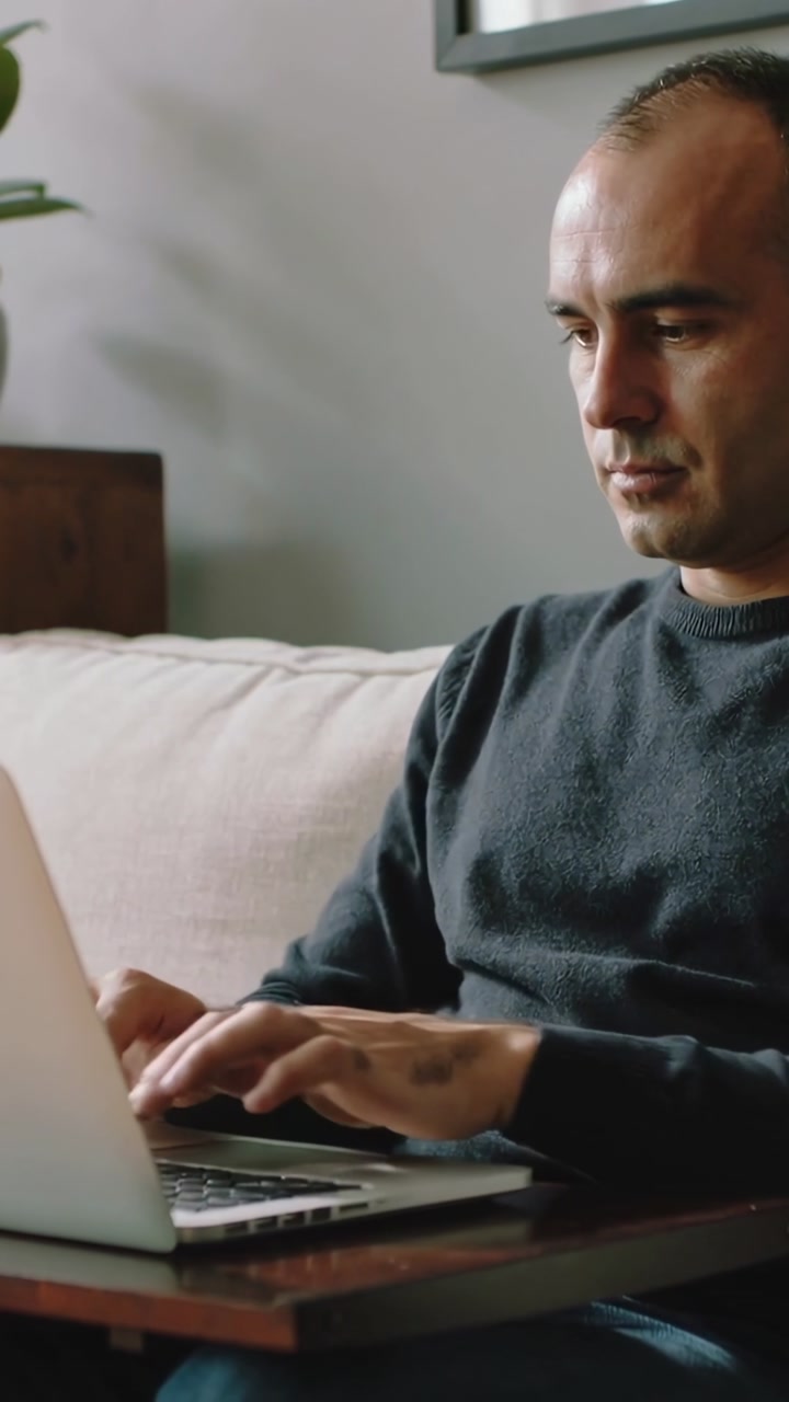 Focused Man Working Remotely on Laptop from Home