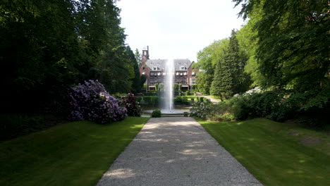 Low-aerial-towards-fountain-in-front-of-beautiful-mansion