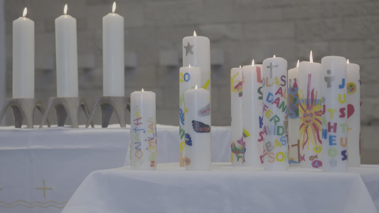 colorful candles stand burning on an altar in a church