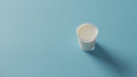 video of glass of fresh milk over blue background