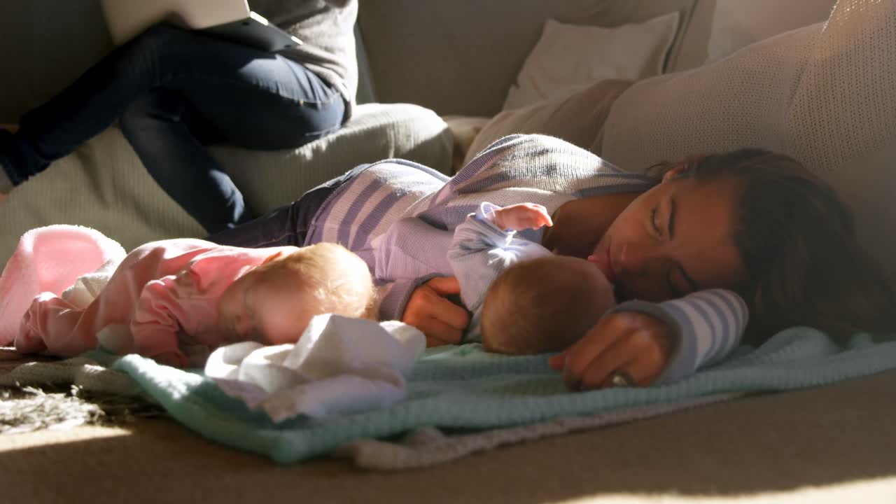 Mother sleeping her baby boys in living room 4k