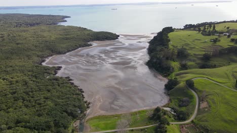 Kontrast-Der-Vulkanischen,-Einheimischen,-Bewaldeten-Insel-Rangitoto-Und-Der-Grünen-Weiden-Der-Insel-Motutapu,-Die-Durch-Einen-Damm-Verbunden-Sind