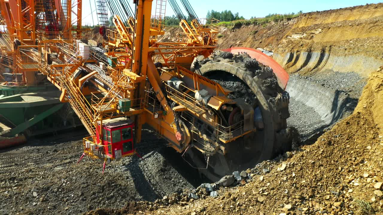 экскаватор с ведрами на работе в угольной шахте.