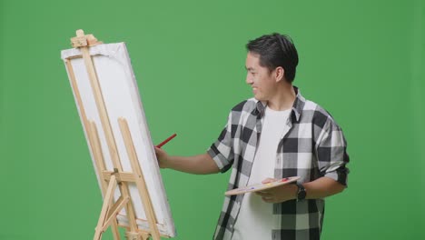 man painting on easel