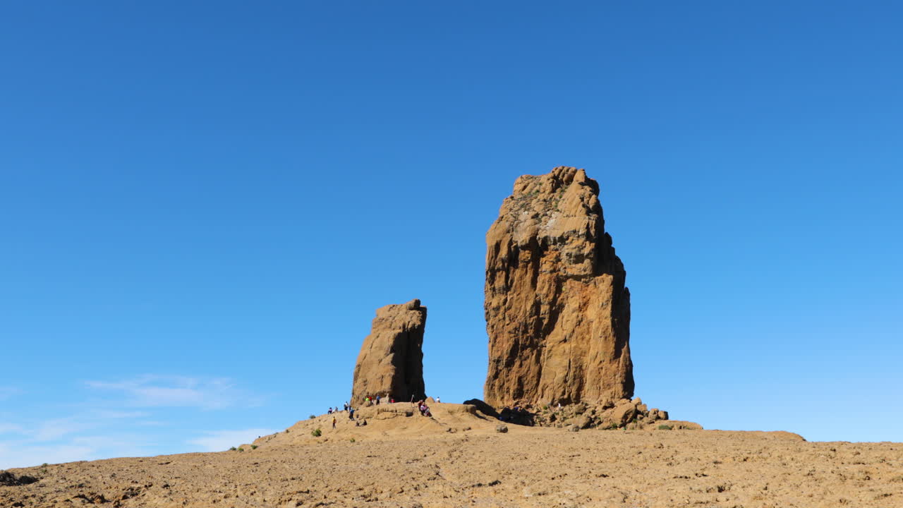 A group of people near a volcanic phenomenon on top of a mountain where they relax after hike Pico de las Nieves Gran Canary island 4k slow motion capture at 60fps