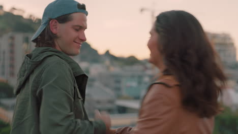 happy caucasian couple dancing on rooftop sharing intimate connection embracing romance hanging out enjoying beautiful view of city at sunset