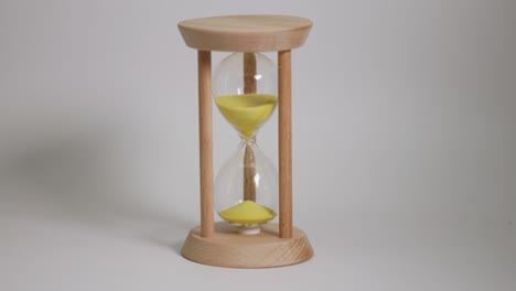 wooden hourglass with yellow sand