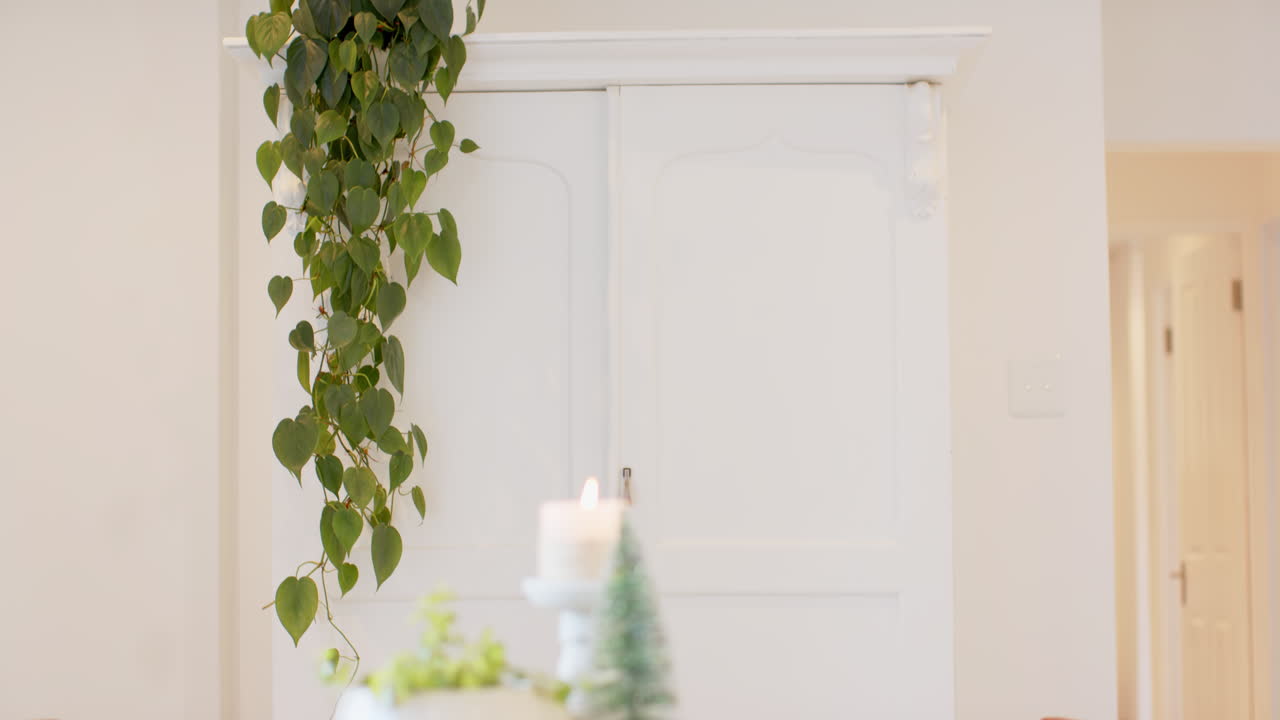 Cozy home decorated with candle and greenery for Christmas celebration, copy space