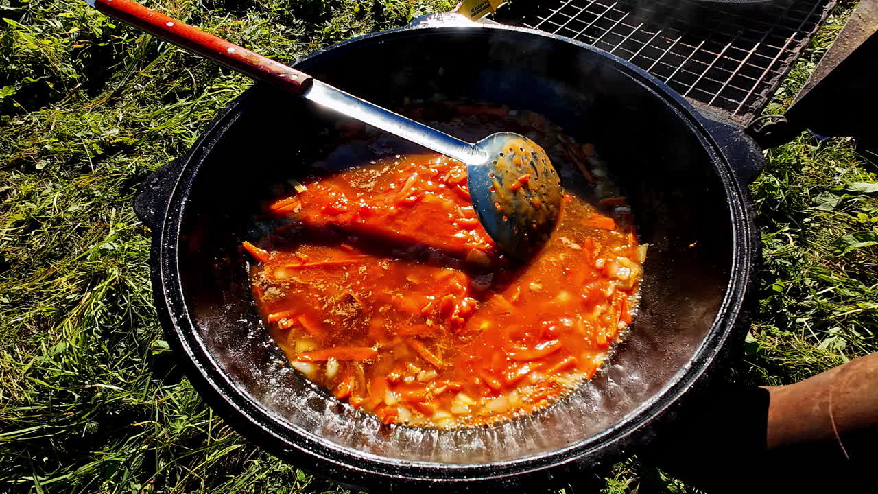 Cooking delicious stew on outdoors BBQ stand, close up