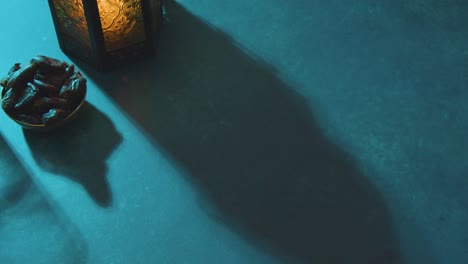 High-Angle-Tracking-Shot-of-Dates-Water-and-Lantern-On-a-Table