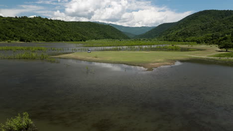 Car-parked-on-Tkibuli-lake-reservoir-shore-during-road-trip-in-Georgia