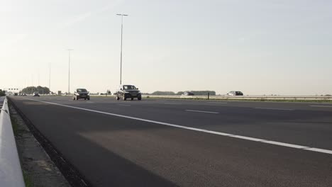 super fast cars and trucks driving on highway on sunny day in holland