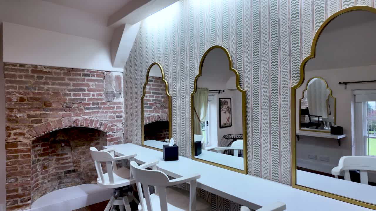 Interior of a vacant vanity suite featuring ornate mirrors and simple seating