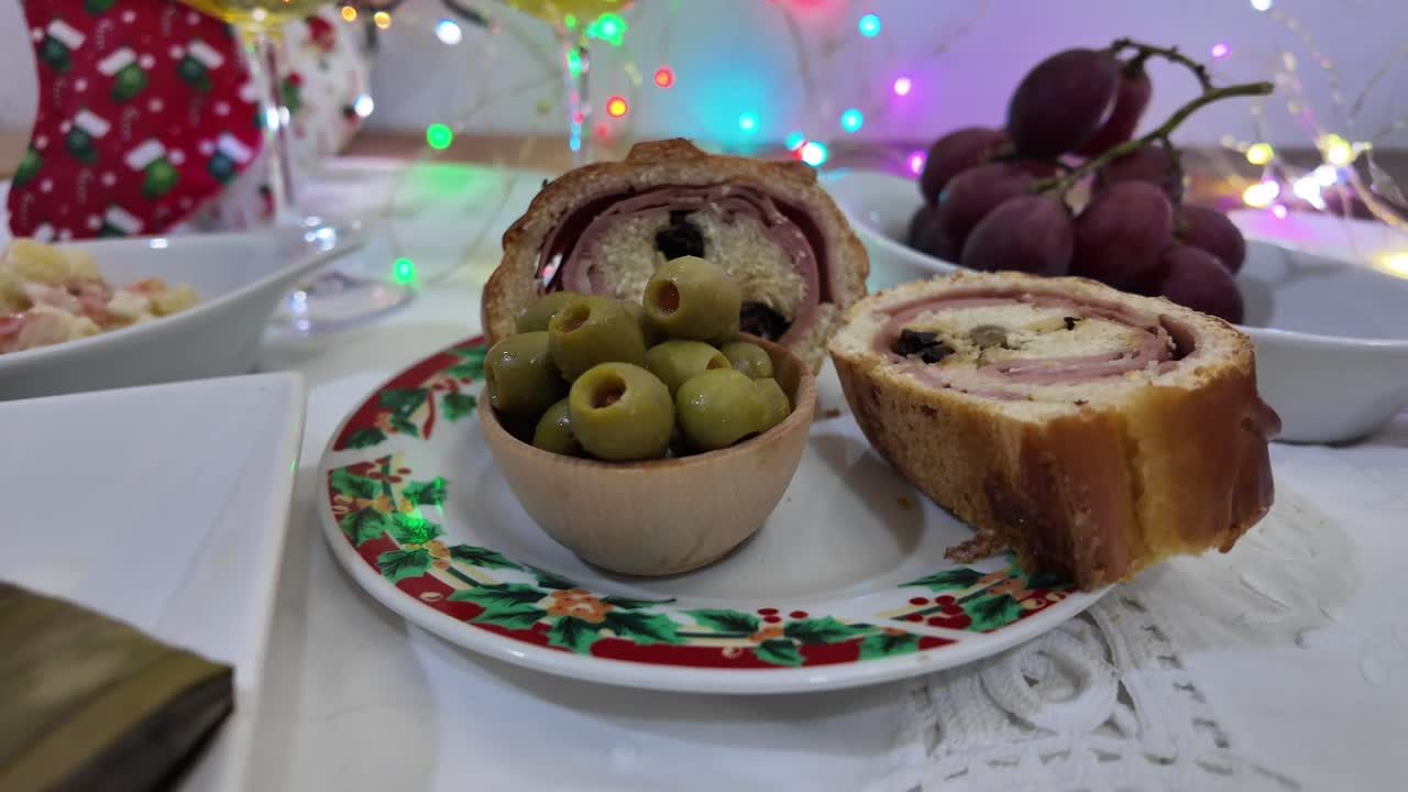 Traditional Venezuelan Christmas food on table with colorful lights in background
