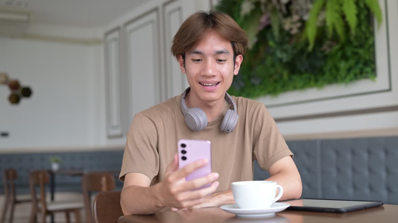 Man sitting and talking on phone with friend while sitting in coffee shop restaurant alone
