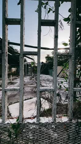 abandoned industrial area behind a weathered metal fence