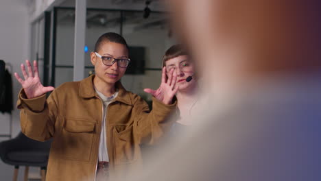 female film director and assistant watching actors shooting movie or video scene in studio