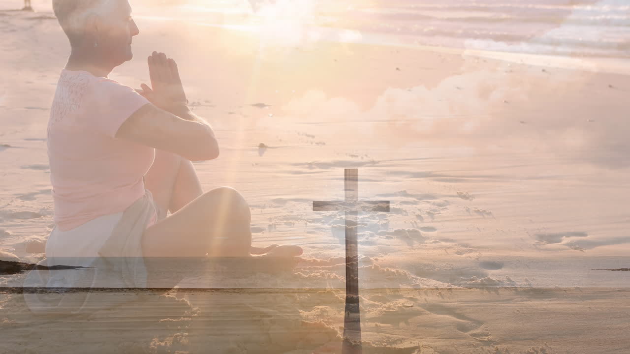 해변에서 기도하는 고위 백인 여성에 대한 십자가의 비디오