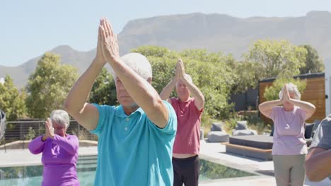 focused diverse senior friends practicing yoga in sunny garden, unaltered, in slow motion