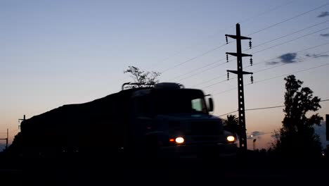 Un-Camión-Y-Un-Coche-Pasan-Por-Una-Ruta-Al-Atardecer