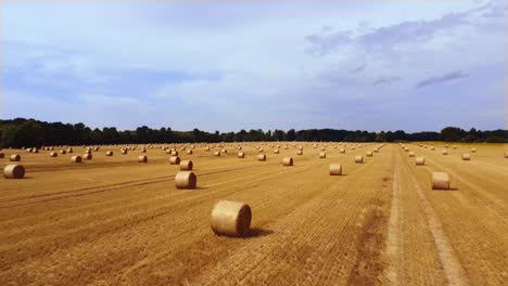 drone flight over straw bales in a field on a beautiful day in summer