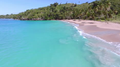 Paraíso-En-La-Tierra-Con-Agua-Clara,-Playa-Privada-Y-Plantación-De-Palmeras-En-La-Costa-Bajo-El-Sol---Playa-Colorada,-Las-Galeras