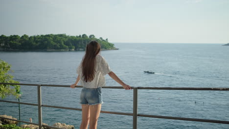 woman enjoying the sea view from a viewpoint