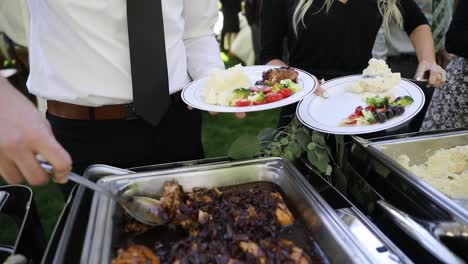 close up shot of wedding guest serving delicious catered food during mariage party