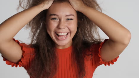 caucasian curly haired woman fooling around in front of the camera.