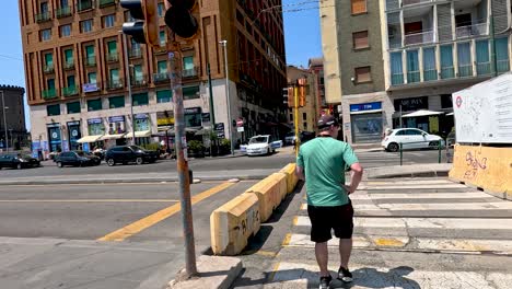 man crossing street near buildings in naples, italy