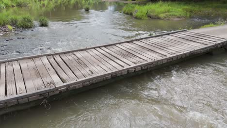 wooden bridge spans a fast-moving river