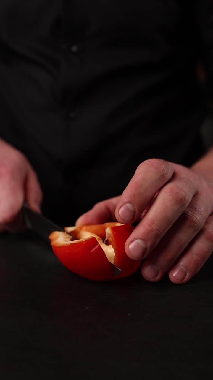 el chef cortando un pimienta roja