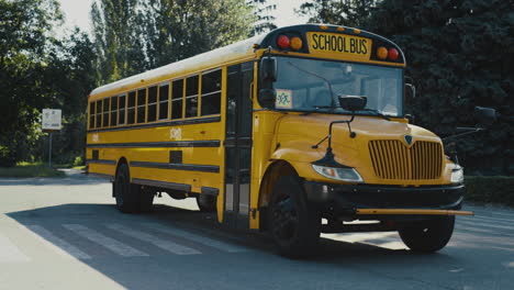 empty yellow school bus standing on parking lot surrounded greenery sunny day.