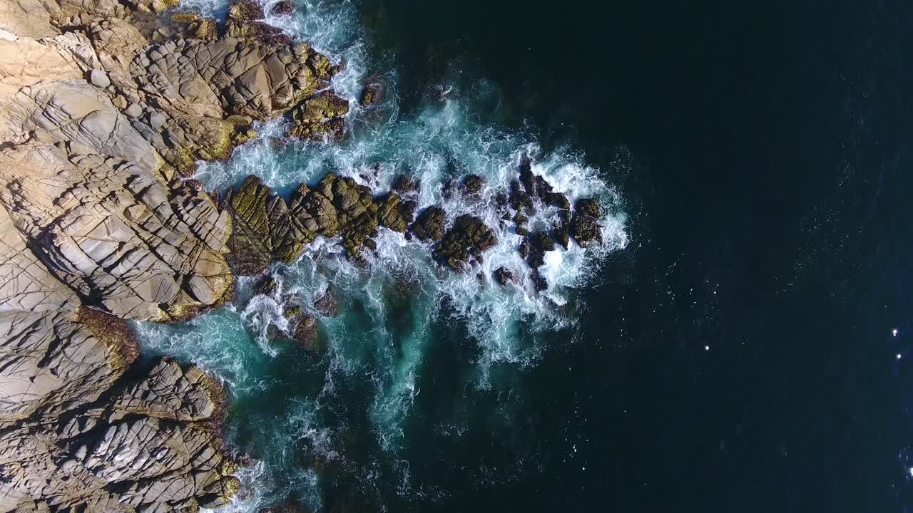 Veduta aerea delle onde oceaniche che si schiantano sulla costa rocciosa