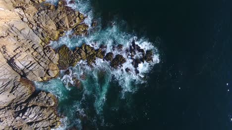 aerial view of ocean waves crashing on rocky coast