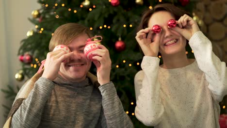 pareja jugando con adornos de navidad