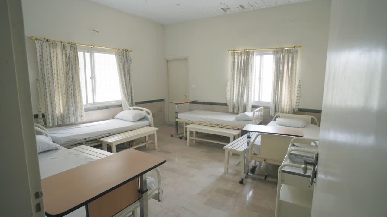 Revealing shot of multiple empty beds in a ward of hospital during daytime in Pakistan.