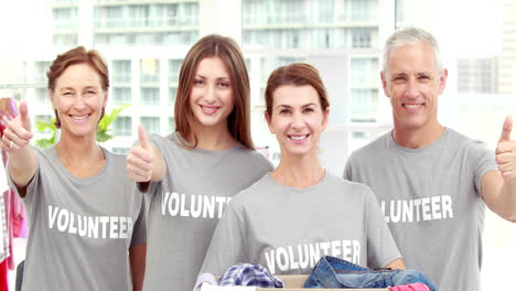 smiling friends volunteers separating clothes