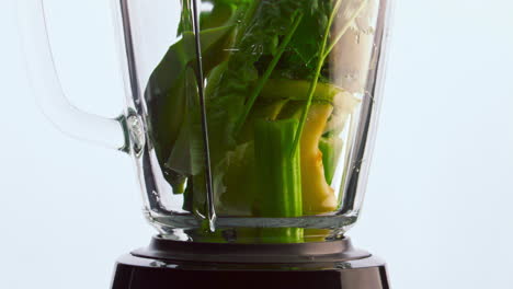 raw vegetables blender bowl on white background close up. vitamin cocktail.