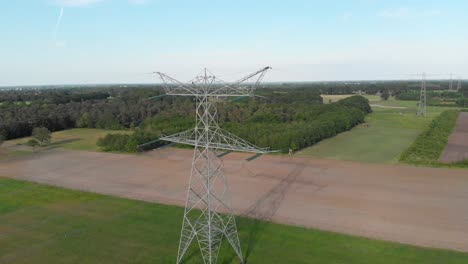 european countryside electricity transmission towers and power lines, blue sky aerial view
