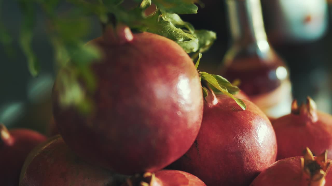 카메라는 서로 위에 쌓인 빨간 석류에서 슬로우 모션으로 축소합니다.