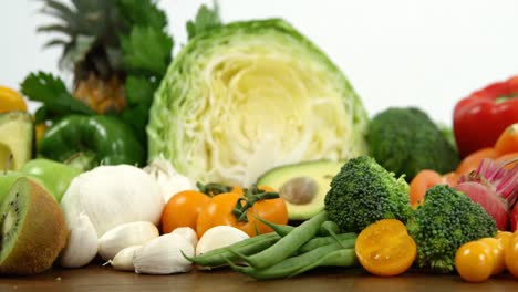 Variety-of-fresh-colored-vegetables-and-fruits-on-wooden-table