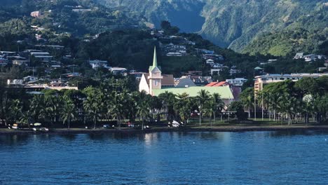 papeete, tahiti island, french polynesia. protestant church of paofai and city promenade under green hills